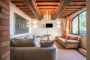 a living room with two couches and a chandelier at Podere Erbolino in Gaiole in Chianti