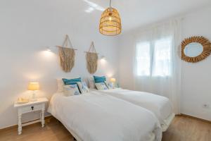a white bedroom with two beds and a mirror at El Pinito Moraira in Moraira +35 photos