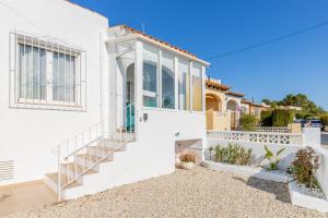 a white house with a staircase leading to the front door at El Pinito Moraira in Moraira