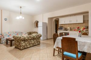 a kitchen and living room with a table and a couch at Moraki Apartment 1 Andros in Korthi