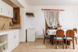 a kitchen and dining room with a table and chairs at Moraki Apartment 1 Andros in Korthi +14 photos