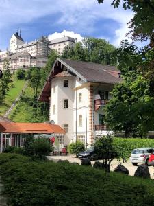 a large white building with cars parked in front of it at Ferienwohnung im Burghotel in Aschau im Chiemgau