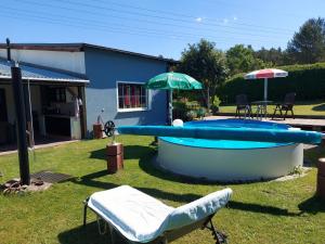 a swimming pool with an umbrella and two chairs and a table at Ferienwohnung in Spreewaldnähe in Kolkwitz +6 photos