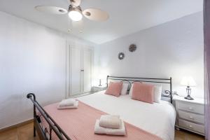 a bedroom with a bed with pink pillows on it at Vista al Mar Ylenia in Almería +20 photos