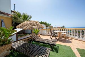 a patio with two chairs and a table and an umbrella at Vista al Mar Ylenia in Almería