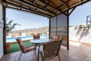 a patio with a table and chairs and a pool at Vista al Mar Ylenia in Almería