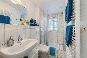 a white bathroom with a sink and a toilet at Ferienwohnung Rosenrot in Überlingen +18 photos