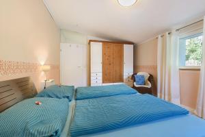 a bedroom with two beds and a window at Ferienwohnung Rosenrot in Überlingen