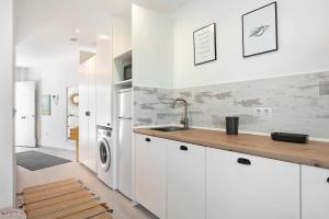 a kitchen with white cabinets and a sink at Casa Maracuya in Tarifa