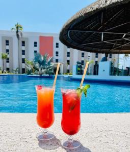two cocktails sitting on the sand next to a pool at Hotel Royal Garden Tuxpan in Cobos +9 photos