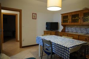 a kitchen with a table with chairs and a tv at Oliva's House con giardino in Palazzolo dello Stella