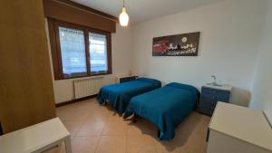 a room with two beds and a window at Oliva's House con giardino in Palazzolo dello Stella