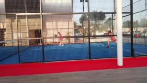 two girls playing tennis on a tennis court at Hotel Royal Garden Tuxpan in Cobos