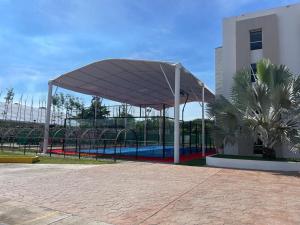 a canopy over a swimming pool in a park at Hotel Royal Garden Tuxpan in Cobos