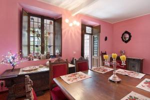 a dining room with pink walls and a wooden table at Villa Oleandra - Como Lake in Dizzasco