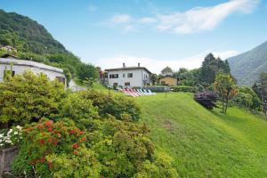 a house on the side of a hill with a yard at Villa Oleandra - Como Lake in Dizzasco