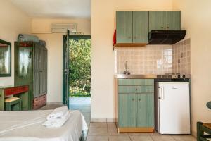 a kitchen with green cabinets and a white refrigerator at Anemona studio C in Kefallonia