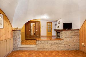 a living room with a stone fireplace and a tv at Caratteristico e accogliente in Pila