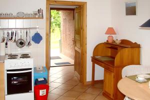 a kitchen with a stove and a counter with a table at Ferienwohnung Achterndiek in Galmsbüll