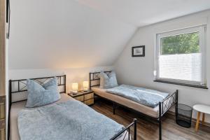 two beds in a room with a window at Ferienhaus Heidi in Bad Düben