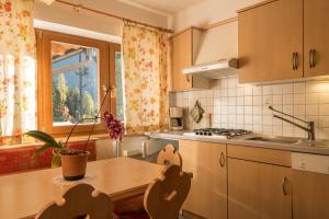 a kitchen with a table and a sink and a window at Ferienwohnung Sella Seis in Siusi