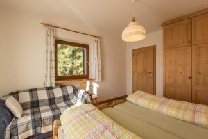 a living room with two beds and a window at Ferienwohnung Sella Seis in Siusi