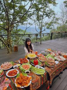a woman sitting at a table full of food at The SkyView Villa & Resort in Kệ Sơn