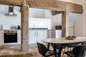 a kitchen with a table and chairs in a room at Casa do Mestre T2 in Vila de Punhe