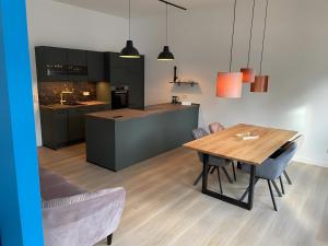 a kitchen and dining room with a wooden table at Design Apartment Flair u Komfort in Meschede