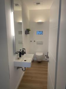 a bathroom with a white sink and a toilet at Design Apartment Flair u Komfort in Meschede