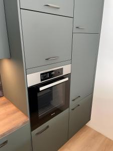 a kitchen with a stainless steel oven and cabinets at Design Apartment Flair u Komfort in Meschede +5 photos