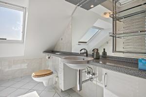a bathroom with a sink and a toilet at Dachstübchen in Hagenburg +25 photos