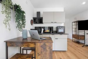 a kitchen with a wooden table with a laptop on it at Global Bnb - Ay Homes in Augsburg