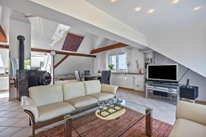 a living room with a couch and a tv at Dachstübchen in Hagenburg