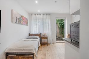 a white bedroom with a bed and a television at Global Bnb - Ay Homes in Augsburg