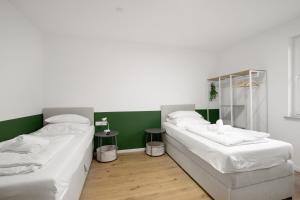 two beds in a room with green and white at Business Apartment in Oberkochen in Oberkochen