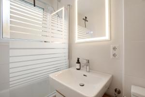 a white bathroom with a sink and a shower at Business Apartment in Oberkochen in Oberkochen +20 photos