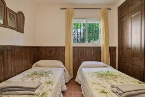 two beds in a room with a window at Casa Cantarrana in Arriate +39 photos