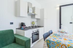 a kitchen with a table and a green chair in a room at Villetta Vanessa in Avola