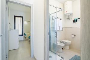 a bathroom with a glass shower and a toilet at Villetta Vanessa in Avola +17 photos