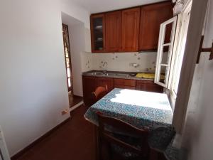 a small kitchen with a table and a sink at Ester Home Procchio Mare E Sole in Marciana