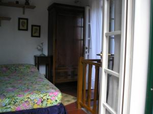 a bedroom with a bed and an open door at Ester Home Procchio Mare E Sole in Marciana