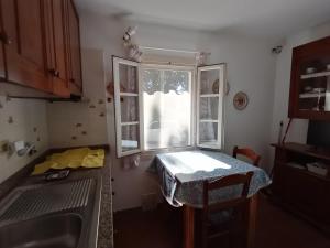 a small kitchen with a table and a window at Ester Home Procchio Mare E Sole in Marciana +21 photos