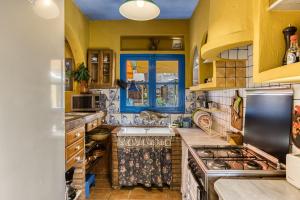 a kitchen with yellow cabinets and a blue window at Casa en urb Cala Montgó in L'Escala +25 photos