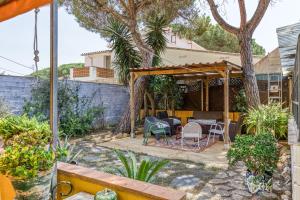 a patio with a table and chairs under a pergola at Casa en urb Cala Montgó in L'Escala