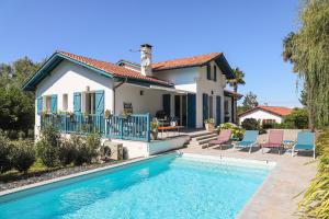 a house with a swimming pool in front of a house at Txori Etxea in Arcangues