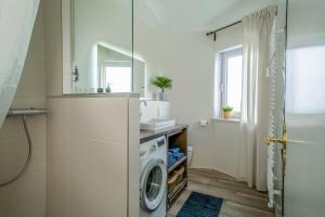 a bathroom with a washing machine and a sink at Heimelig im Allgäu in Lindenberg im Allgäu +21 photos
