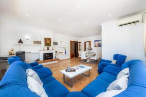 a living room with a blue couch and a table at Pomeres Nou in Sa Coma