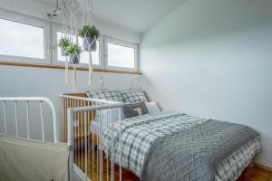 a small bedroom with a bed and two windows at Heimelig im Allgäu in Lindenberg im Allgäu