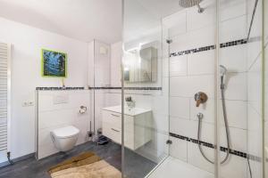 a white bathroom with a shower and a toilet at Ferienwohnung Gäufelden 120 Qm in Gäufelden +19 photos
